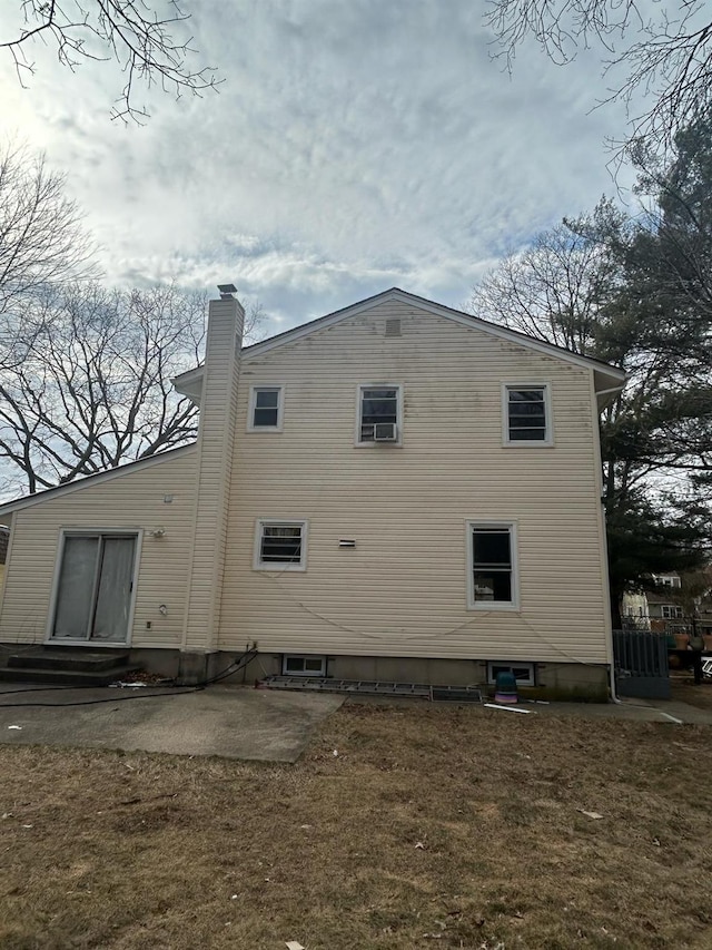 view of side of home with a patio and a chimney