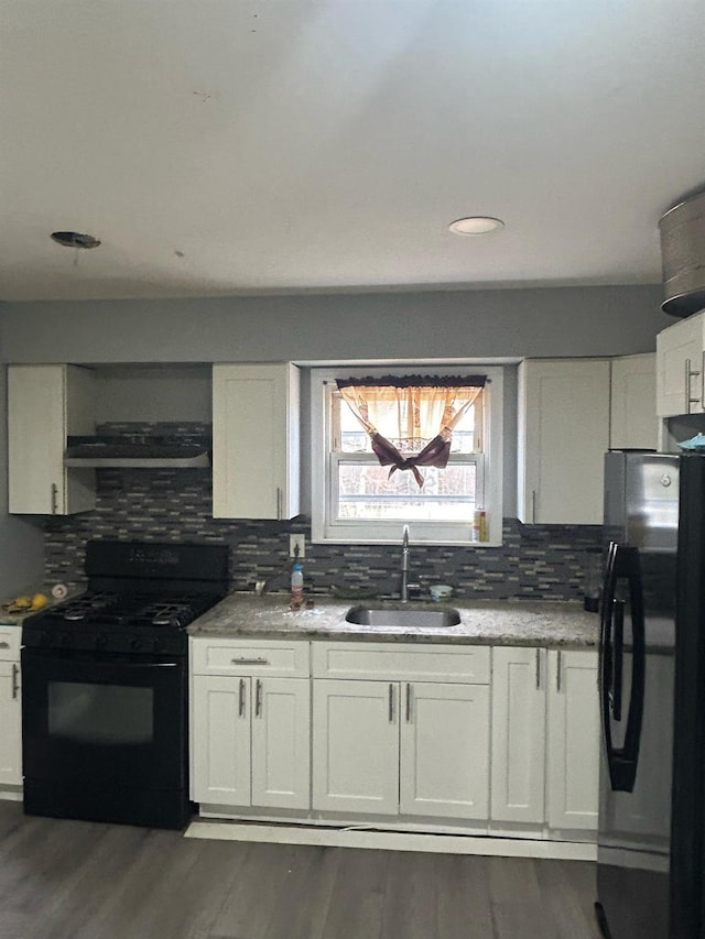 kitchen with white cabinets, a sink, black appliances, and exhaust hood