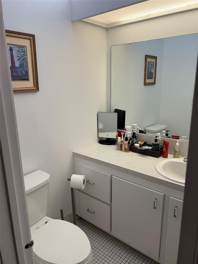 half bath featuring tile patterned floors, toilet, and vanity