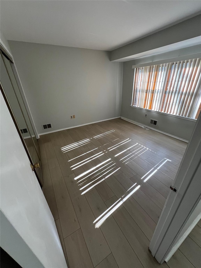 empty room featuring visible vents and wood finished floors