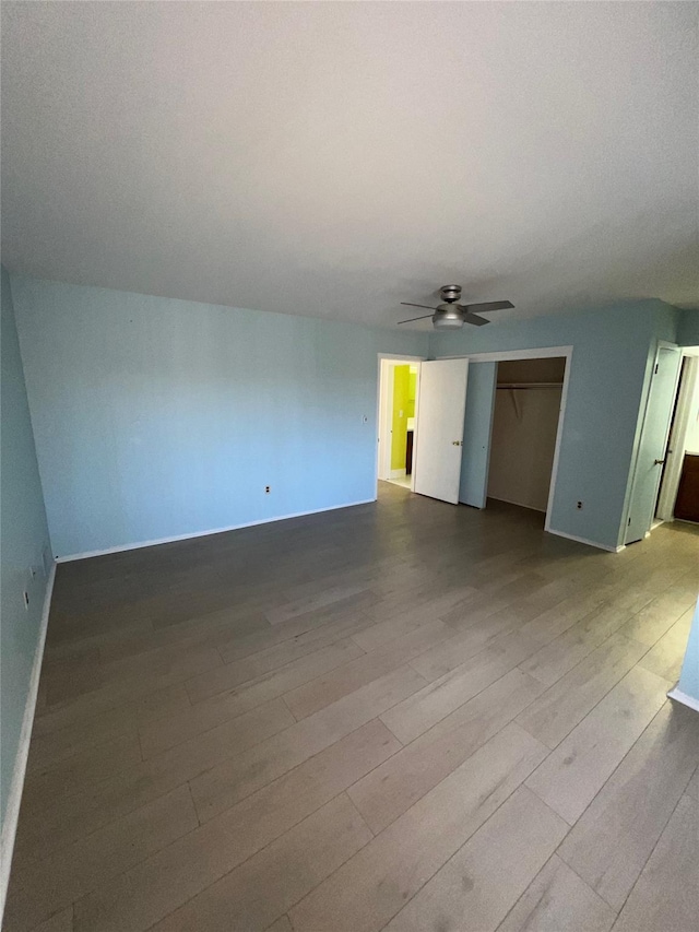 unfurnished living room featuring a ceiling fan and wood finished floors