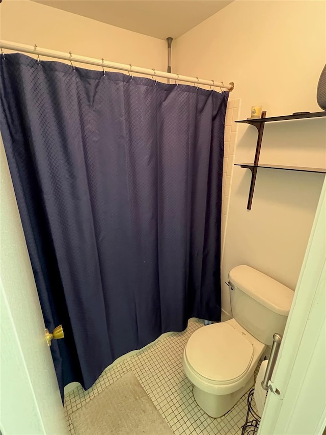 bathroom featuring tile patterned floors, curtained shower, and toilet