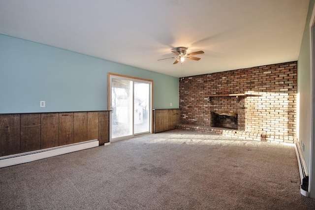 unfurnished living room with a wainscoted wall, baseboard heating, a ceiling fan, and carpet floors