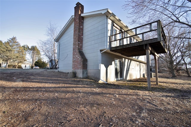 view of side of home featuring a wooden deck and a chimney