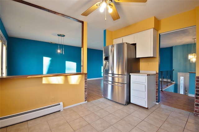 kitchen featuring light tile patterned flooring, baseboard heating, white cabinetry, and stainless steel refrigerator with ice dispenser