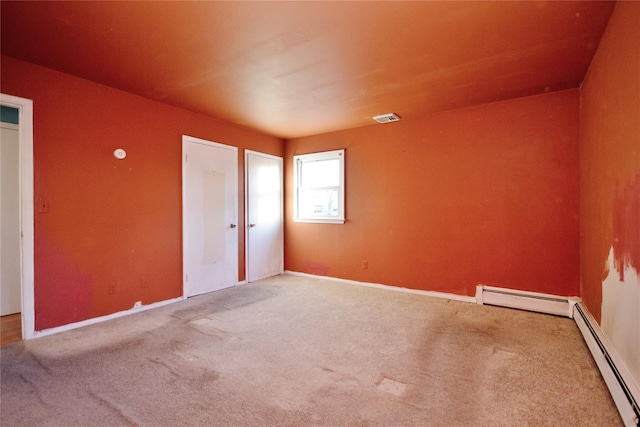 carpeted empty room with visible vents and baseboard heating