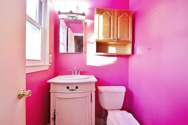 bathroom featuring plenty of natural light, toilet, and vanity