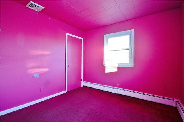 carpeted empty room with a baseboard heating unit, baseboards, and visible vents