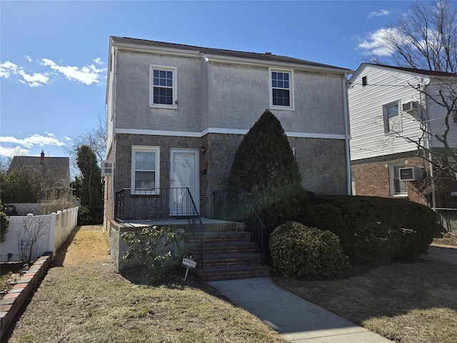 traditional-style house featuring fence and stucco siding