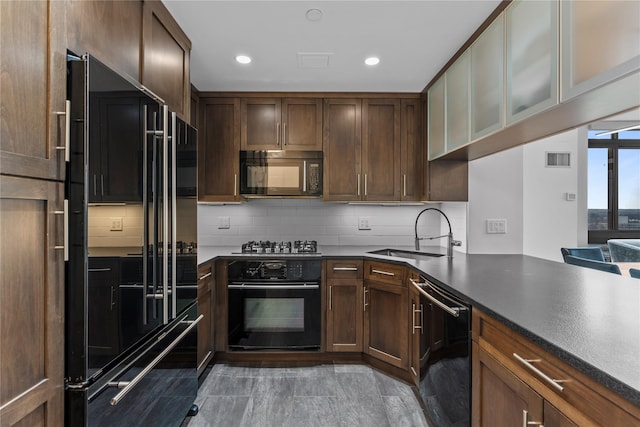 kitchen featuring black appliances, tasteful backsplash, a sink, and visible vents