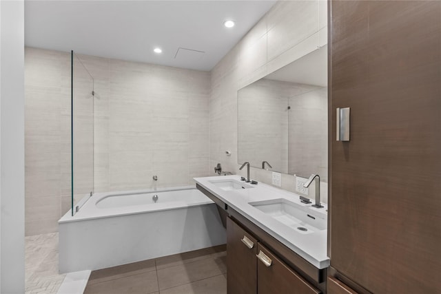 full bathroom with tile patterned flooring, double vanity, a sink, and a bathing tub