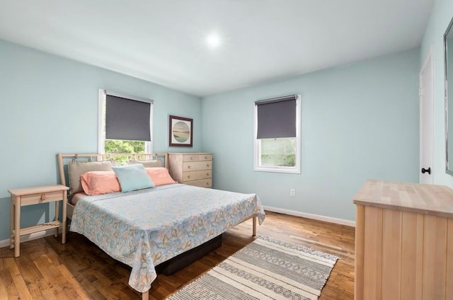 bedroom with baseboards and wood finished floors