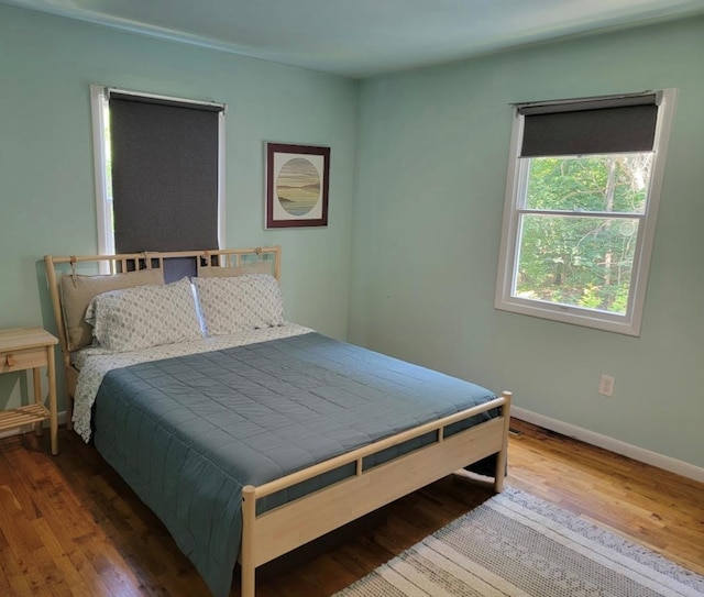 bedroom featuring baseboards and wood finished floors