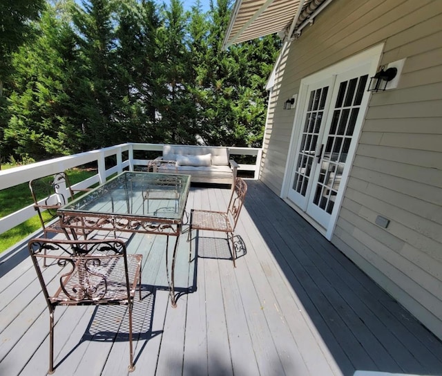 wooden terrace featuring french doors and outdoor dining area