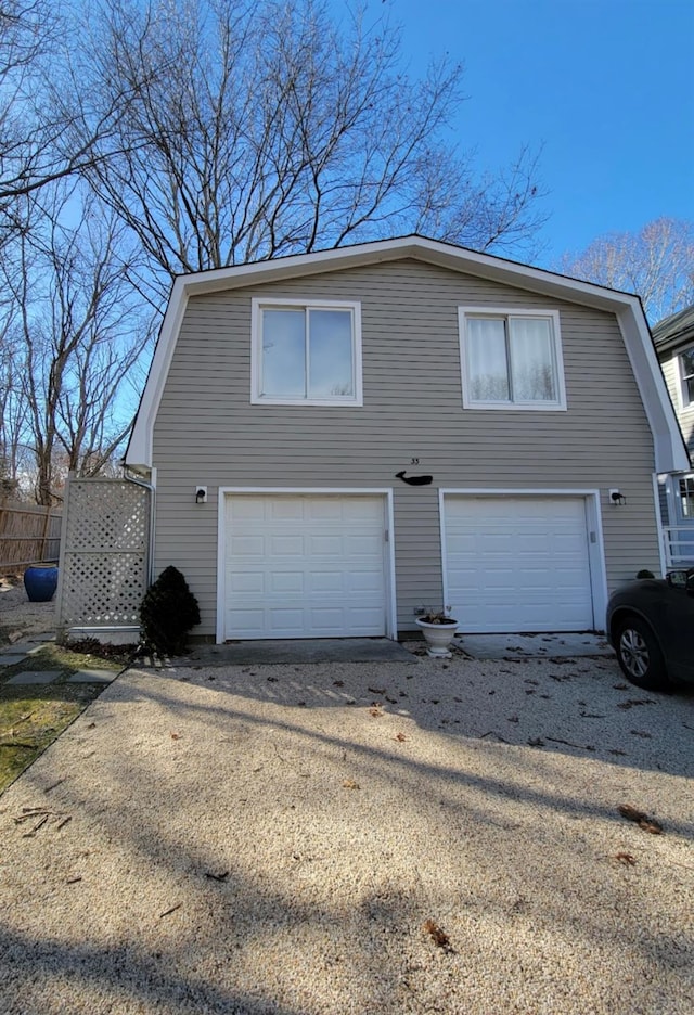 view of front facade with a garage and a gambrel roof