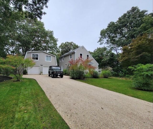 view of front of home featuring driveway, a front lawn, and an attached garage