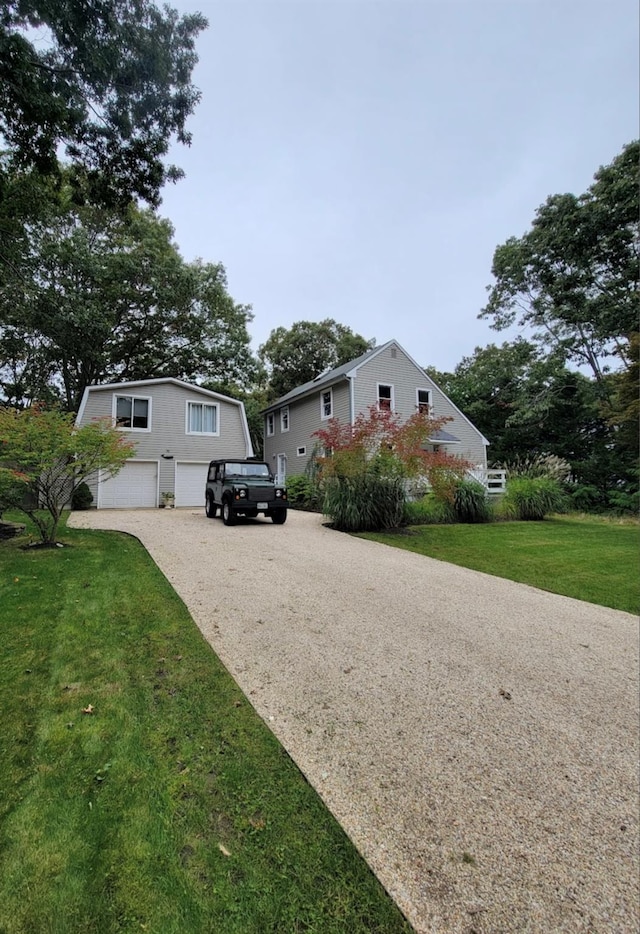 view of front of home with a garage, driveway, and a front lawn