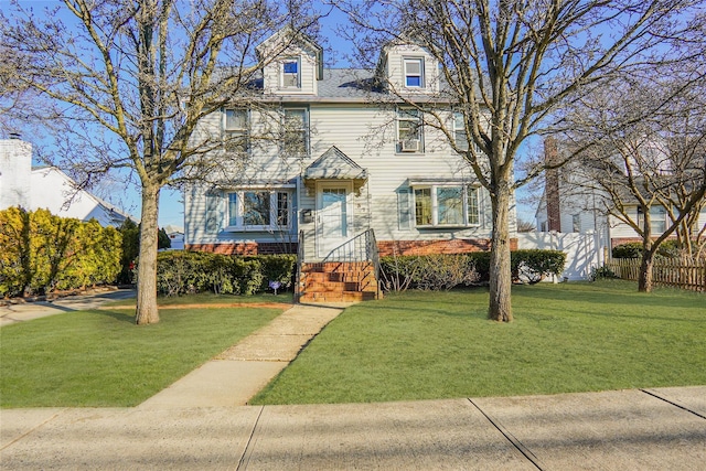 view of front of home with a front yard and fence