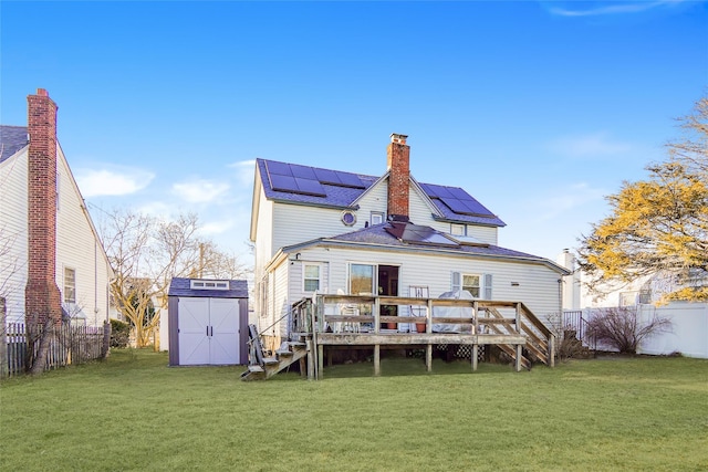 rear view of property with a deck, a storage shed, a yard, and an outdoor structure