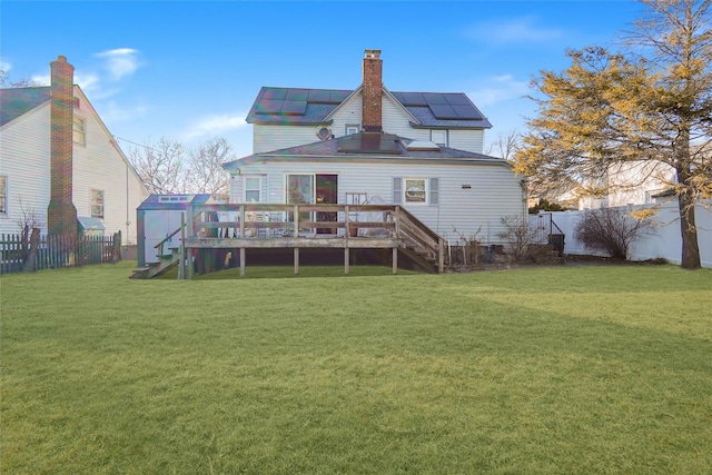 rear view of house with a lawn, a fenced backyard, a chimney, stairs, and a deck