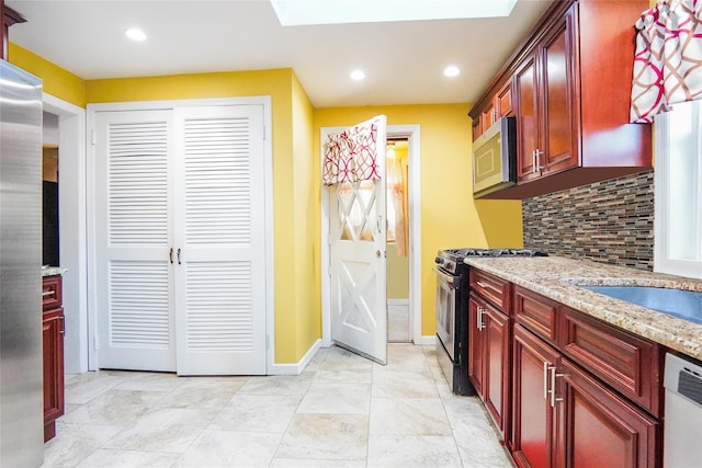 kitchen featuring reddish brown cabinets, stainless steel appliances, backsplash, and recessed lighting