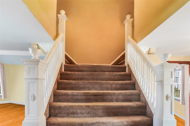 stairway with baseboards and wood finished floors