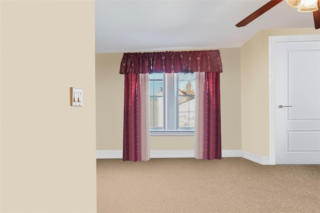 spare room with carpet floors, baseboards, and a ceiling fan