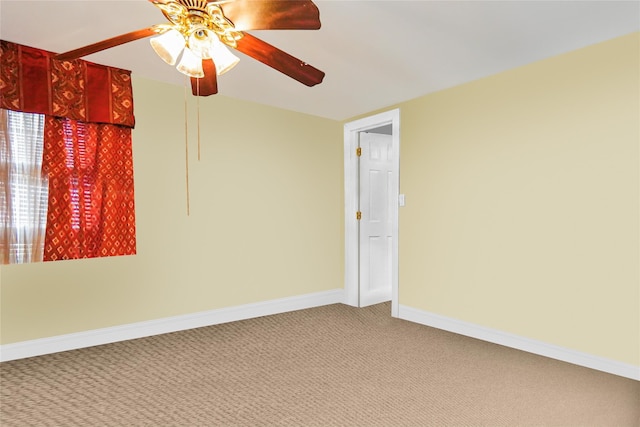 spare room featuring light carpet, ceiling fan, and baseboards