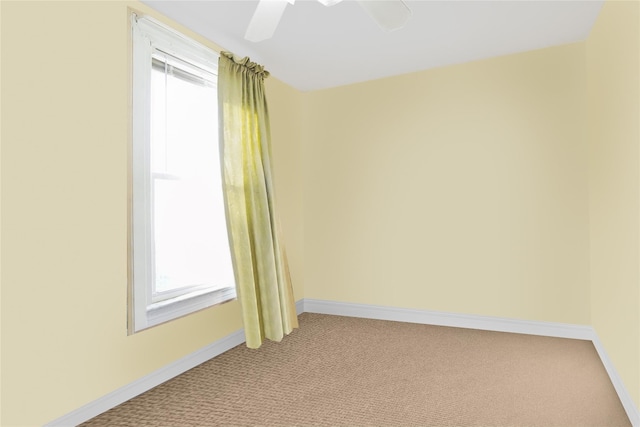 unfurnished room with a ceiling fan, light carpet, and baseboards