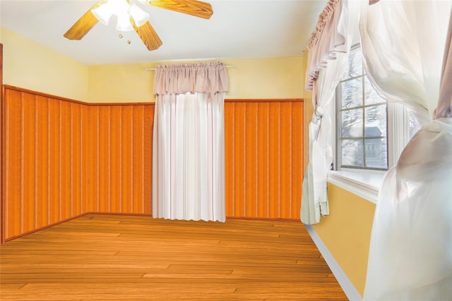 spare room with a wainscoted wall and wood finished floors