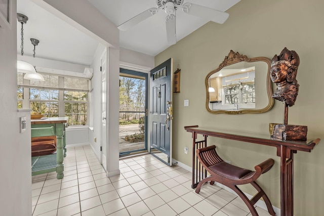 foyer entrance with baseboards, ceiling fan, and light tile patterned floors
