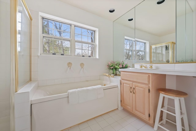 full bathroom featuring a shower stall, a garden tub, vanity, and tile patterned floors