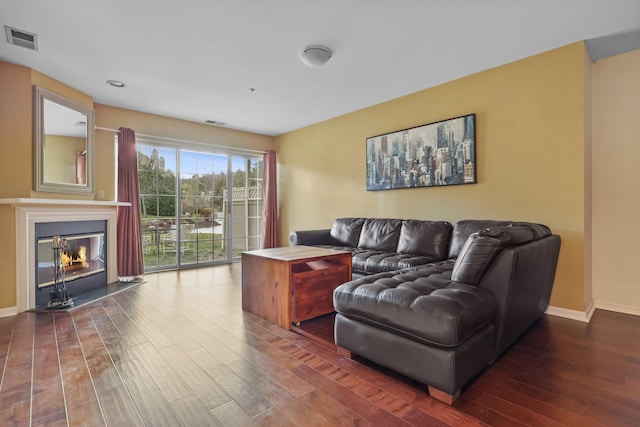 living room featuring baseboards, hardwood / wood-style floors, and visible vents