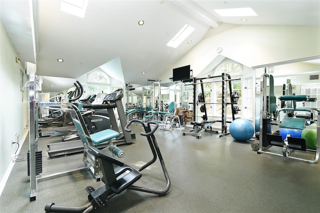exercise room with a wealth of natural light, a skylight, high vaulted ceiling, and visible vents