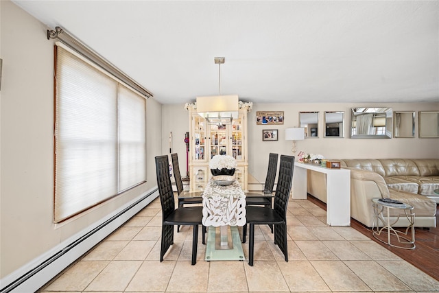 dining room featuring light tile patterned flooring and a baseboard heating unit