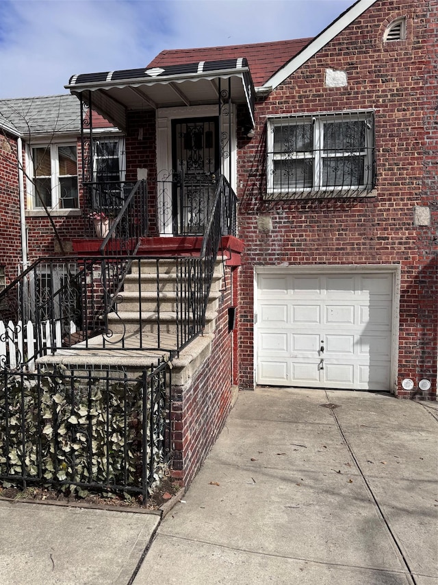 view of front of home with a garage, brick siding, and driveway