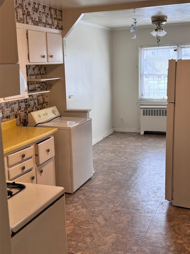 laundry area featuring radiator, washer / clothes dryer, ornamental molding, laundry area, and baseboards