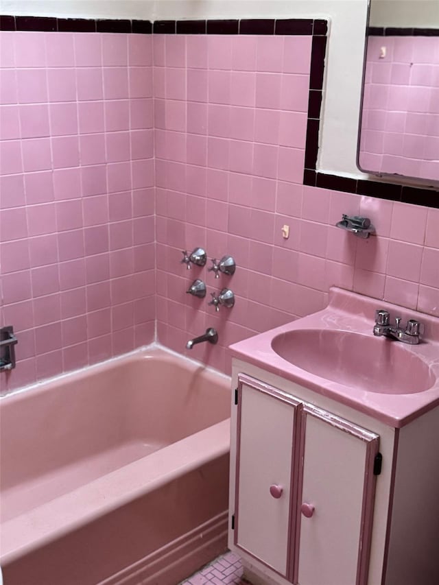 bathroom featuring tub / shower combination, tile patterned flooring, vanity, and tile walls