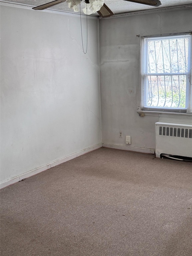 spare room with baseboards, radiator heating unit, a ceiling fan, and light colored carpet