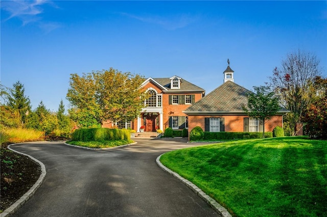 view of front of house with a front lawn and brick siding