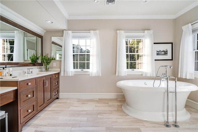 full bathroom featuring visible vents, a freestanding bath, vanity, and a healthy amount of sunlight