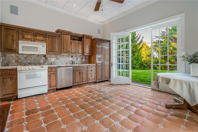 kitchen featuring white appliances, visible vents, a high ceiling, crown molding, and backsplash