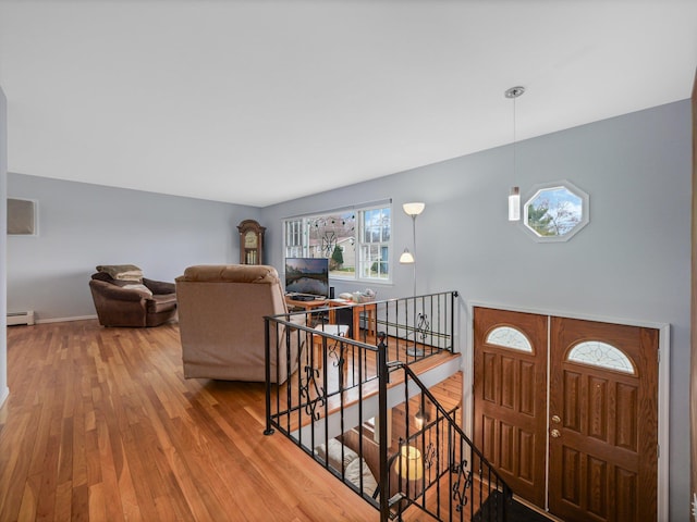 foyer featuring baseboards, baseboard heating, and wood finished floors