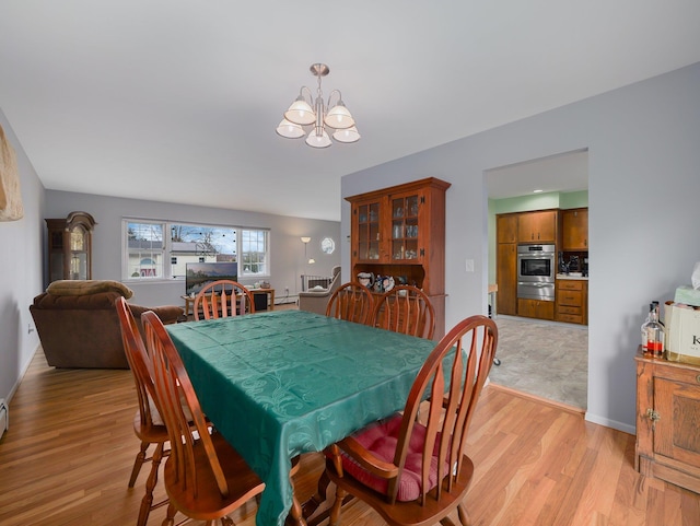 dining room featuring light wood-style flooring and a chandelier