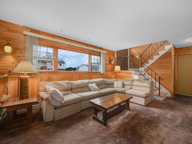 living area with stairway, wooden walls, and carpet floors