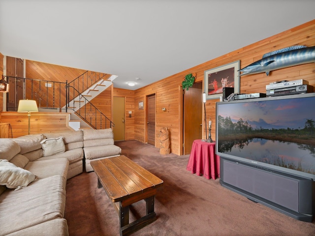 carpeted living area with stairway and wood walls