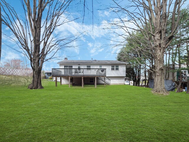 back of house featuring a deck, a yard, and stairs