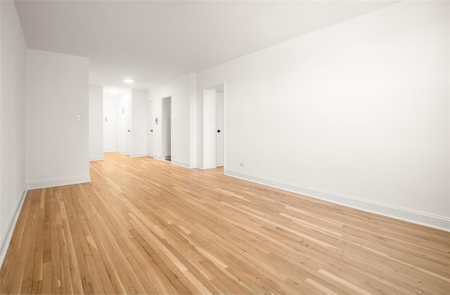 spare room featuring light wood-type flooring and baseboards