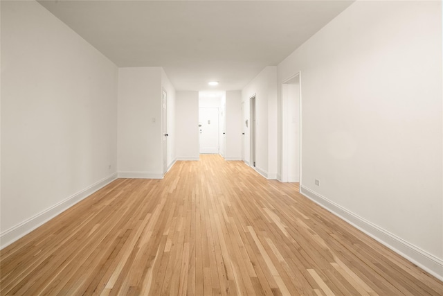 empty room featuring baseboards and light wood-style floors