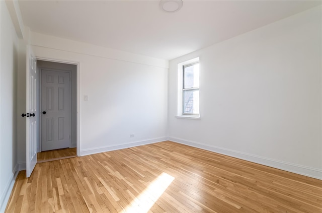 empty room featuring light wood-style flooring and baseboards